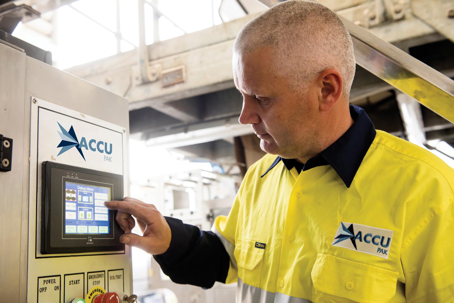 AccuPak technician operating a packaging machine control panel